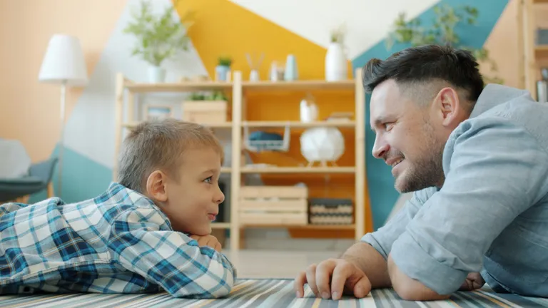 far og søn ligger på gulvet